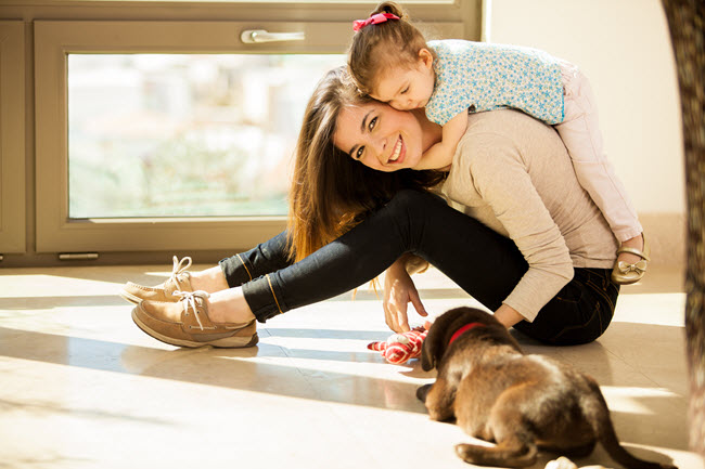 Mother and Daughter Playing With Dog.